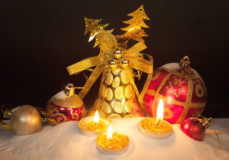 Burning candles in a Christmas setting with seasonal decorationsの写真素材
