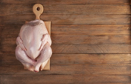 raw chicken  on a wooden cutting boardの写真素材