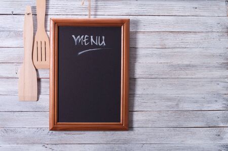 Blackboard on wooden surface and serving spoonsの写真素材