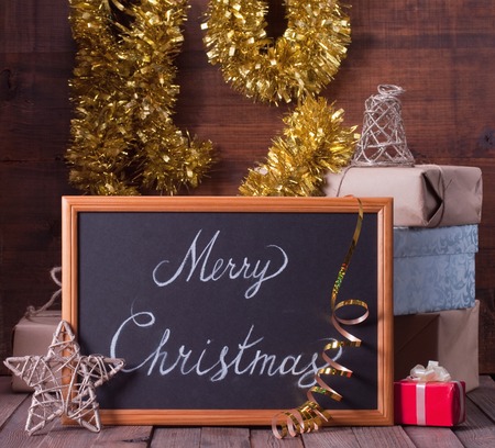 boxes with Christmas presents and blackboard on a wooden backgroundの写真素材