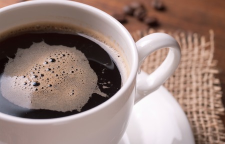 A cup of coffee or hot chocolate and female feet with socks on.. A cup of coffee or hot chocolate and female feet with socks on..