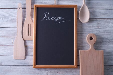 Blackboard on wooden surface and serving spoonsの写真素材