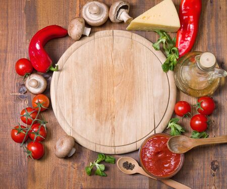Pizza ingredients  and tray on wooden boardの写真素材