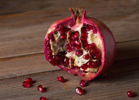 Sliced granate fruit on old wooden tableの写真素材