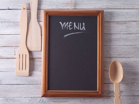 Blackboard on wooden surface and serving spoonsの写真素材