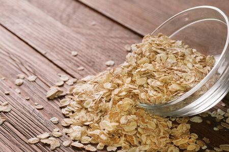 rolled oats heaped in a glass bowlの写真素材