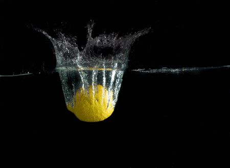 Sliced lemon in the water on black backgroundの写真素材