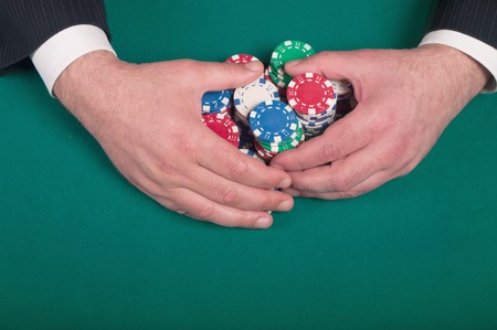 hands rakes the pile of poker chips