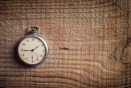 Old  pocket watch on wooden background.の写真素材