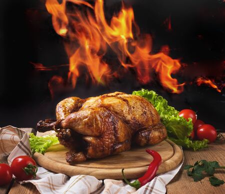 Whole chicken on background of flamesの写真素材