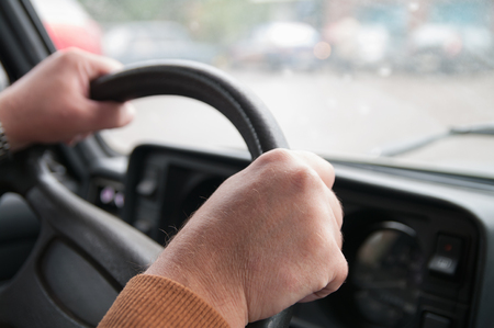 Close-up Of A Man Hands Holding Steering Wheel While Driving Carの写真素材