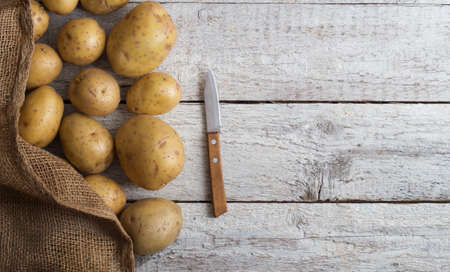 Fresh potatoes on an old wooden tableの写真素材