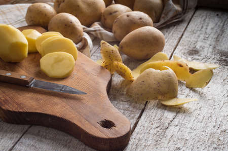 Fresh potatoes on an old wooden tableの写真素材
