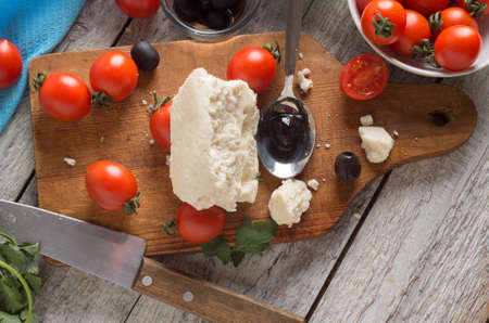 ingredients for greek salad on a wooden board