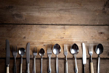 vintage used cutlery on dark brown wooden table