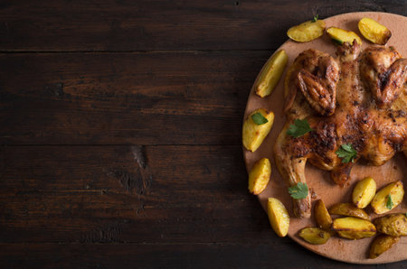 Whole roasted chicken on wooden boardの写真素材