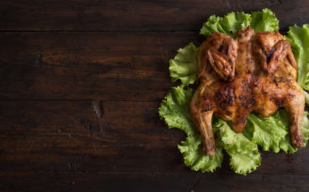 Whole roasted chicken on wooden boardの写真素材