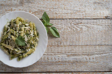 Penne Pasta with Pesto Sauce on White Plate with Forkの写真素材