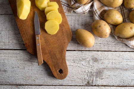 Fresh potatoes on an old wooden tableの写真素材