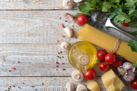 spaghetti and ingredients on wooden backgroundの写真素材