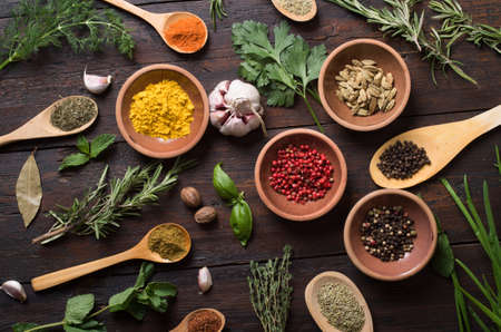 Fresh spices thyme, turmeric, cardamom, basil, mint, parsley, dill and rosemary on wooden background.の写真素材