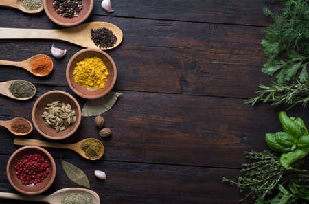 Fresh spices thyme, turmeric, cardamom, basil, mint, parsley, dill and rosemary on wooden background.の写真素材
