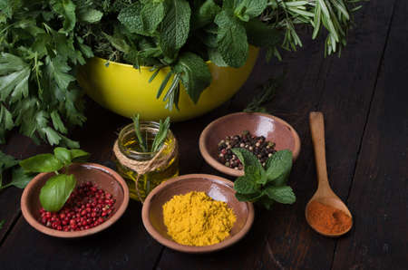 Fresh spices thyme, turmeric, cardamom, basil, mint, parsley, dill and rosemary on wooden background.の写真素材