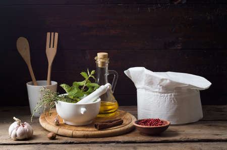 Chef's hat on an old wooden table. Conceptual background on the theme of food.の写真素材