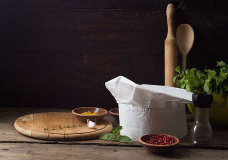 Chef's hat on an old wooden table. Conceptual background on the theme of food.の写真素材