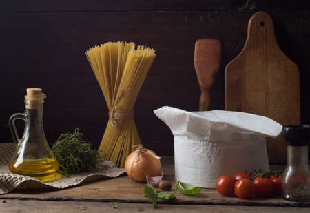 Chef's hat on an old wooden table. Conceptual background on the theme of food.の写真素材