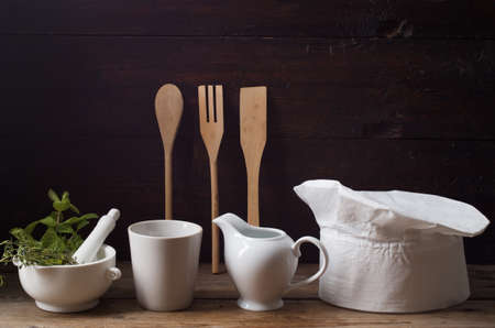 Chef's hat on an old wooden table. Conceptual background on the theme of food.の写真素材