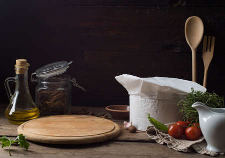 Chef's hat on an old wooden table. Conceptual background on the theme of food.の写真素材