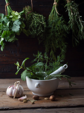Fresh spices thyme, turmeric, cardamom, basil, mint, parsley, dill and rosemary on wooden background.の写真素材