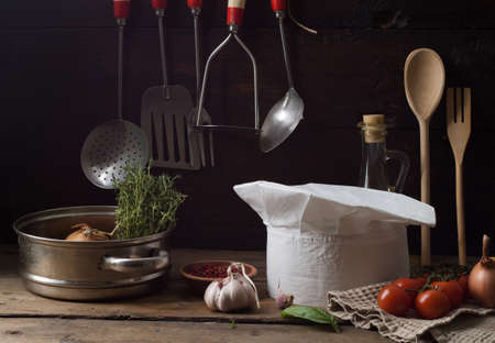 Chef's hat on an old wooden table. Conceptual background on the theme of food.の写真素材