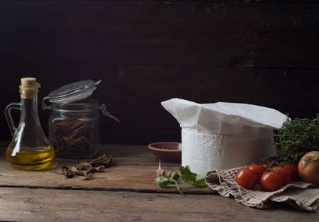 Chef's hat on an old wooden table. Conceptual background on the theme of food.の写真素材