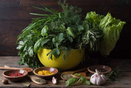 Fresh spices thyme, turmeric, cardamom, basil, mint, parsley, dill and rosemary on wooden background.の写真素材