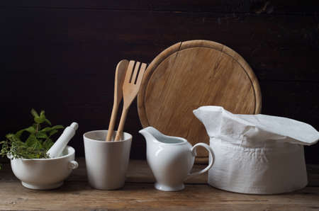 Chef's hat on an old wooden table. Conceptual background on the theme of food.の写真素材