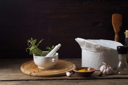 Chef's hat on an old wooden table. Conceptual background on the theme of food.の写真素材