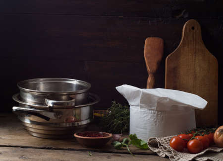 Chef's hat on an old wooden table. Conceptual background on the theme of food.の写真素材