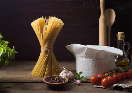 Chef's hat on an old wooden table. Conceptual background on the theme of food.の写真素材