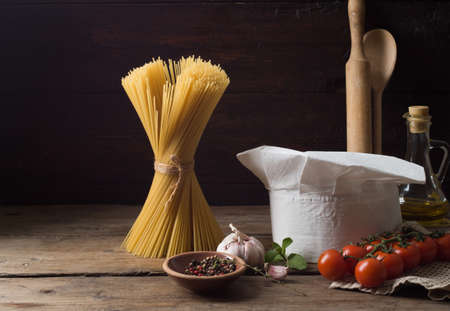 Chef's hat on an old wooden table. Conceptual background on the theme of food.の写真素材