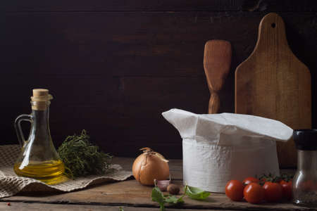 Chef's hat on an old wooden table. Conceptual background on the theme of food.の写真素材