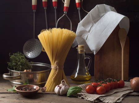 Chef's hat on an old wooden table. Conceptual background on the theme of food.の写真素材