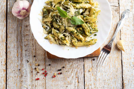 Penne Pasta with Pesto Sauce on White Plate with Forkの写真素材