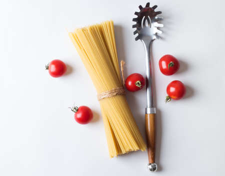 Spaghetti with ingredients for cooking pasta on a white background, top viewの写真素材