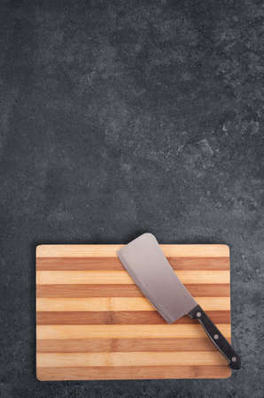 Rustic wooden cutting board on black stoneの写真素材