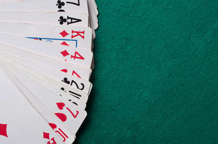 Cards on green felt casino table background.