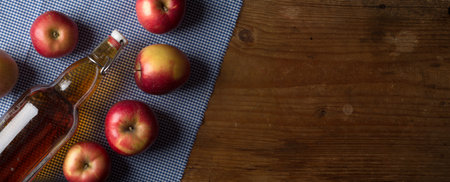 Cider with apples and bottle on rustic wooden backgroundの写真素材