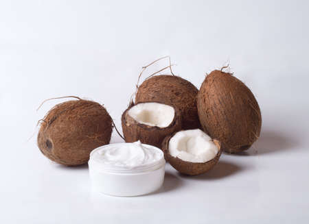 organic cosmetic cream and coconut on white