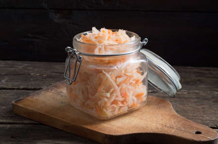 Sour cabbage fermented sauerkraut with carrot in a old wooden tableの写真素材